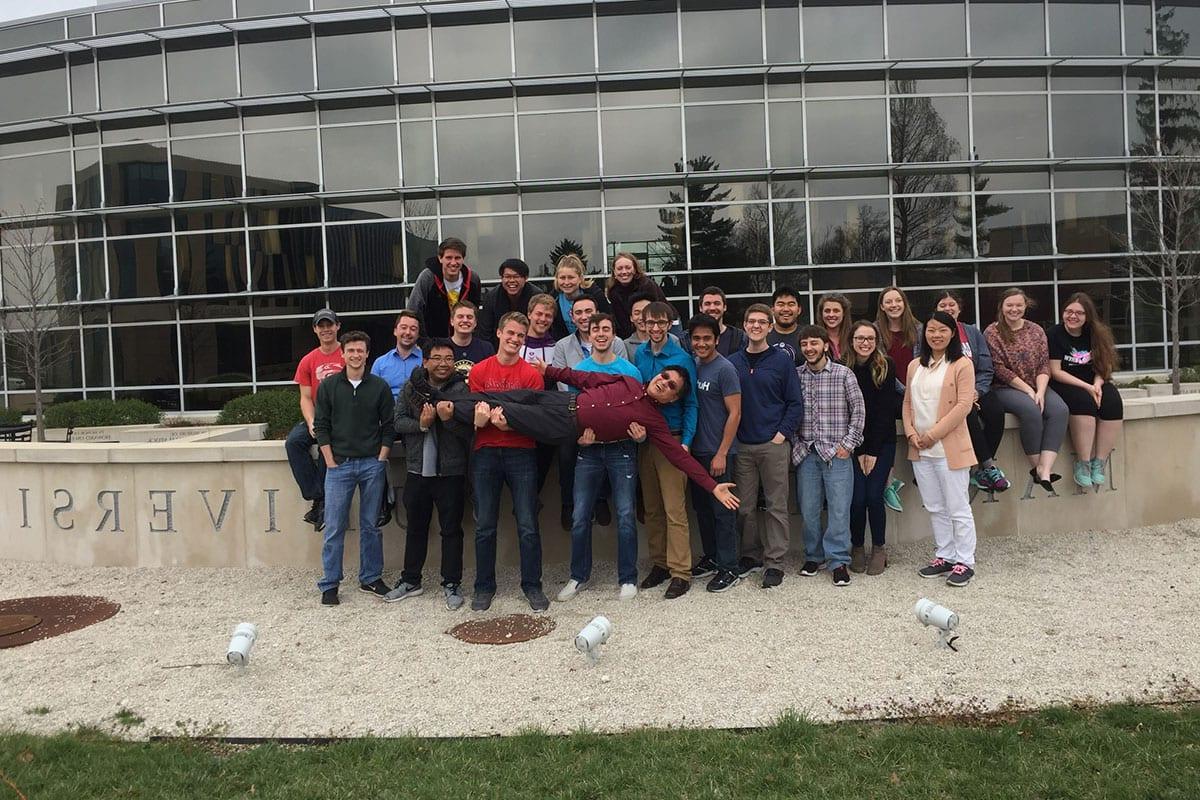 Data Science program director Guangwei Fan with students in front of Gander Hall